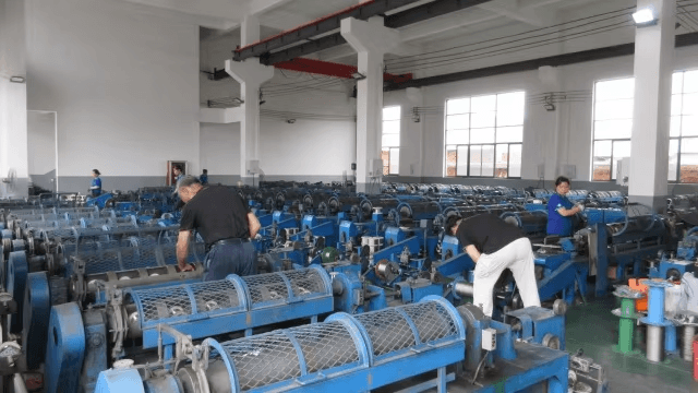 Workers operating wire rope manufacturing machines at Guangtong factory